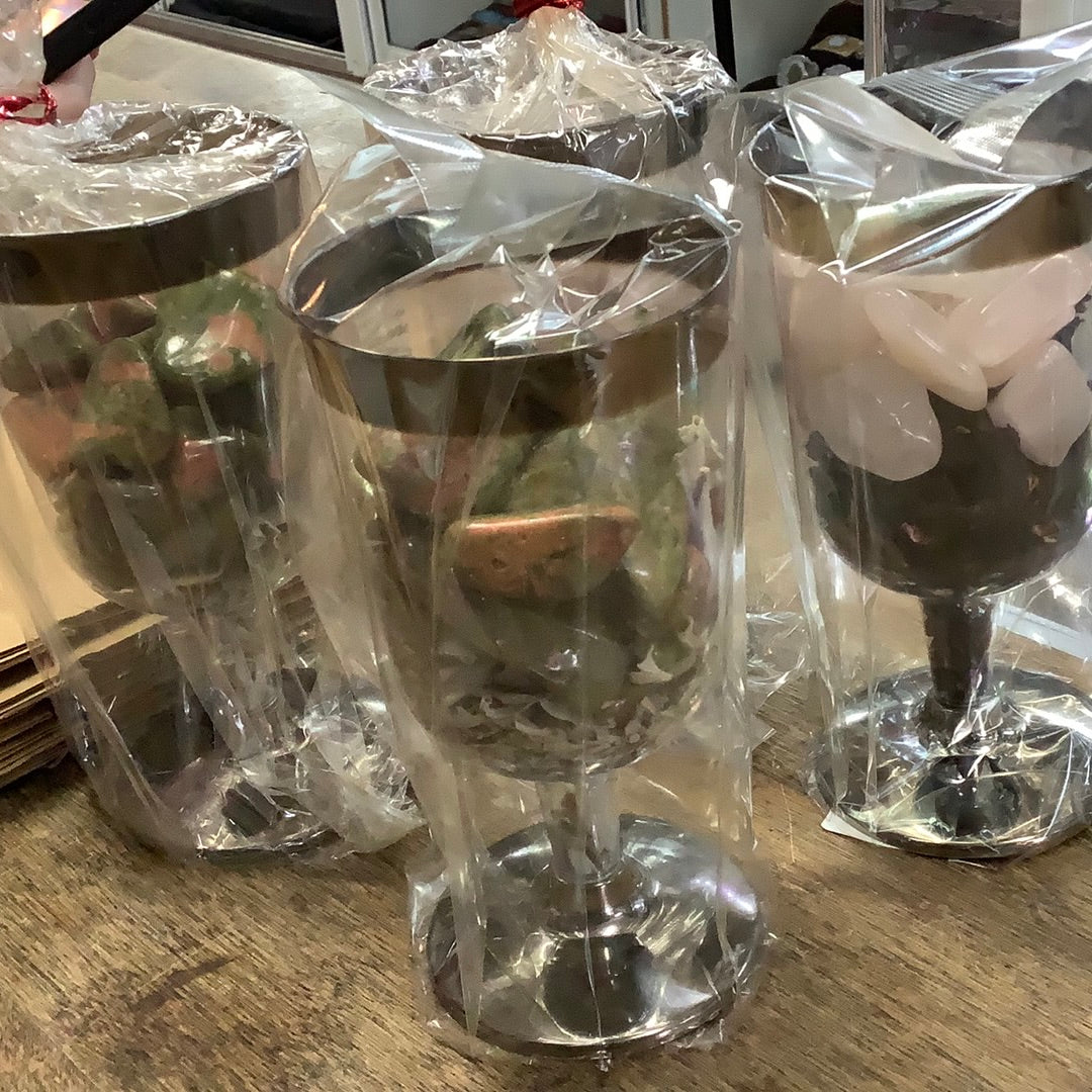 Plastic wine glass with stones and herbs